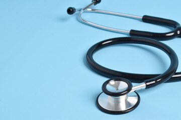 Stethoscope on light blue background, closeup. Space for text