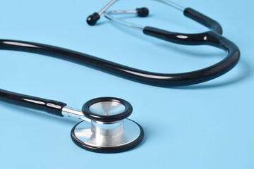 Stethoscope on light blue background, closeup
