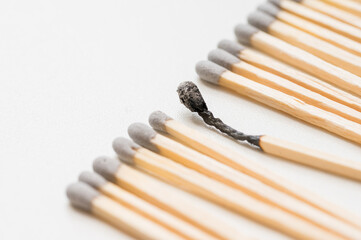 Group of matches and one burned match, burnout abstract concept
