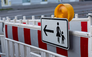Pedestrian sign directing people to cross to the other side, attached to a red-and-white...