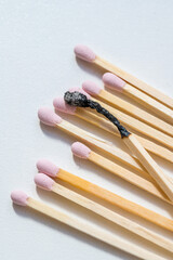Group of pink matches and one burned match, burnout abstract concept