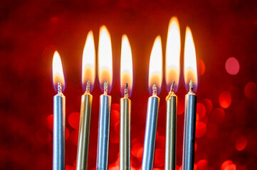 Birthday cake candles with red sparkling red background. Burning candles, celebrating 