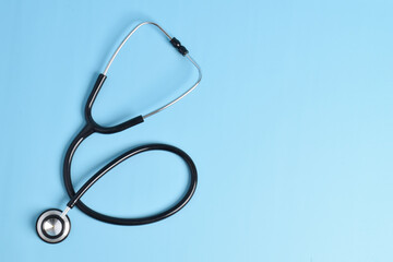 Stethoscope isolated on light blue background, top view. Medical instrument