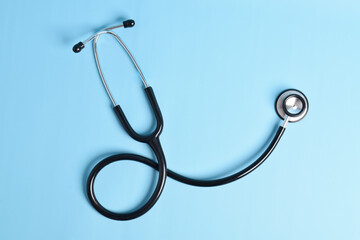 Stethoscope isolated on light blue background, top view. Medical instrument