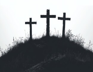 three weathered crosses standing on a grassy hill silhouetted against a bright white sky evoking solemnity and reflection