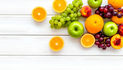 Assorted fresh fruits, including oranges, apples, grapes, and peaches, arranged on a white wooden surface