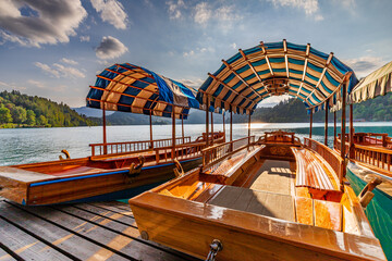 Anchored historic barges on Slovenian Lake Bled, which take tourists to the island with the church