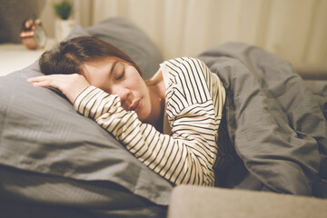 A tired woman wakes early with a headache, struggling with insomnia and fatigue. Low light, stress,...