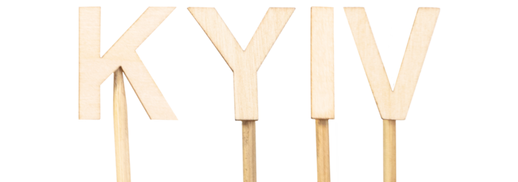 Kyiv, capital of Ukraine, illustrated with firm wooden letters on a white background, strong and symbolic image, adaptable to current or historical contexts