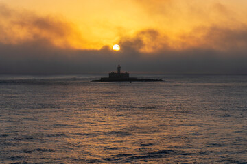 Obraz premium Bujio Lighthouse at the San Lorenzo fortress marks the entrance to the Tagus River estuary in Lisbon. Sunrise view.