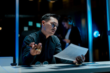 Portrait of a man working overtime at the office. Employee working hard, stressed, tired, working slowly.