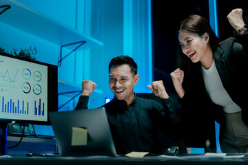 Excited and happy team of colleagues approving projects at night in the office.