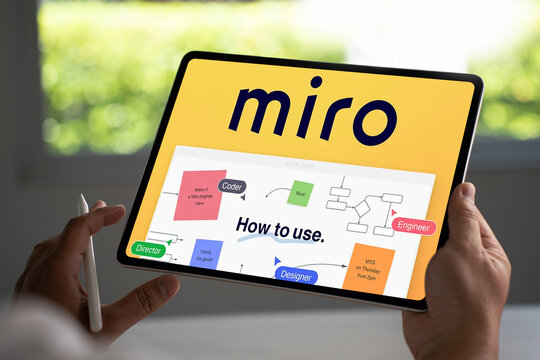Manager using miro online whiteboard platform on tablet for team project management