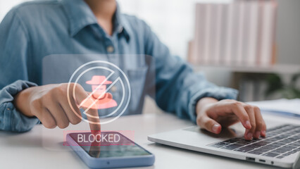 User blocking scam caller on smartphone with hacker icon and blocked symbol. Concept of mobile security, cyber fraud prevention, and protecting personal data from suspicious activities.