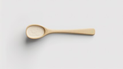 A wooden spoon dipped in creamy yogurt, standing isolated on a spotless white background. This image is a great fit for food - related projects, such as dairy product promotions, healthy eating guides