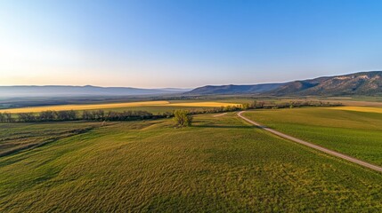 Aerial view of expansive agricultural fields and rolling hills at sunrise