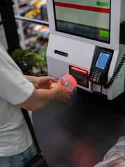 A woman scans items at a self-checkout. 