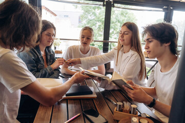 Reading, education concept. Group of young friends are in the cafe restaurant