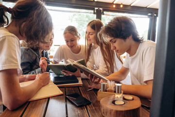 Reading, education concept. Group of young friends are in the cafe restaurant
