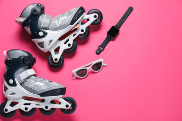 Pair of roller skates, watch and sunglasses on pink background, flat lay. Space for text