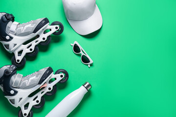 Flat lay composition with roller skates on green background. Space for text