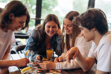 Rest, having good time by sitting by table. Group of young friends are in the cafe restaurant