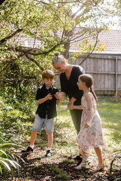 Mother with kids checking a piece of leaf.