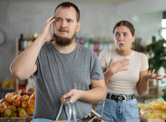 Wife stands behind husband and yells at companion. Angry man is silent and ignores womans...