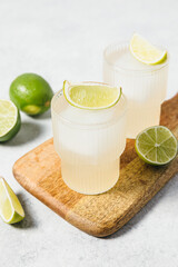 Refreshing detox citrus drink. Vitamin water with lime slices and ice cube on wooden board....