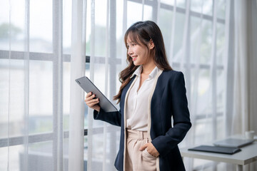 Fototapeta premium Businesswoman working with digital tablet near window in modern office