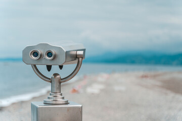 Seaside Binocular Viewer with Blurred Beach Background