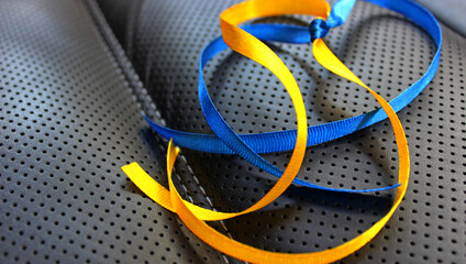 Decorative fabric ribbons of blue and yellow colors on dark textured surface. Symbols and colors of the Ukrainian flag
