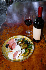 Pork fillet with potatoes and sauce wwith a bottle and a glass of wine