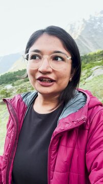 4k vertical selfie video of Indian young woman vlogging during trekking in mountains at Miyar Valley, Himachal Pradesh, India. Happy tourist hiking, sharing experience on social media. Travel blogger