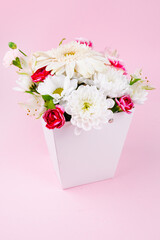 Bouquet with chrysanthemums on a plain pink background, greeting card layout.