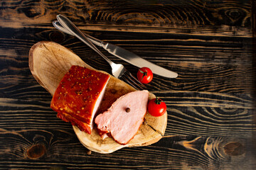 Fresh processed meat, packaged carbonate and pastrami, cutlery and cherry tomatoes in close-up...