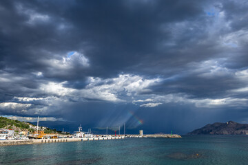 Dramatic sky after a storm, clouds over the Velebit Mountains in Croatia, a colorful rainbow breaks...