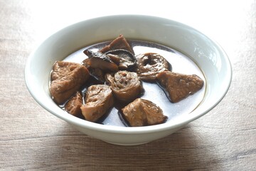 boiled slice tofu and gluten with black mushroom herb soup vegetarian food on bowl