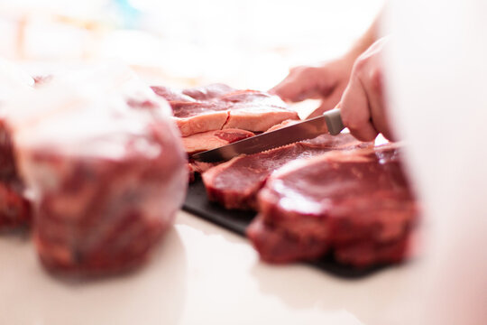 cutting up a bulk meat purchase into portions with knife