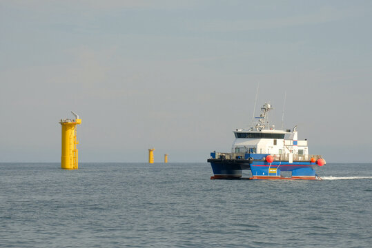 Crew Transfer Vessel Approaching Offshore Wind Turbine on Calm Sea