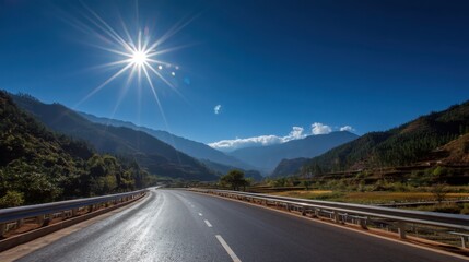 Fototapeta premium Empty road winding through mountains under a bright blue sky and sunshine