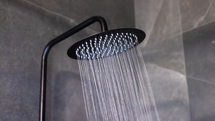 A detailed close up of a shower head with water flowing out of it