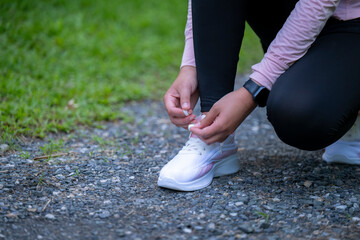 A woman is putting on her running shoes