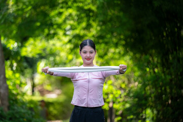 A woman is holding a white scarf in a park