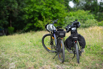 Two touring bicycles parked on grassy field in summer
