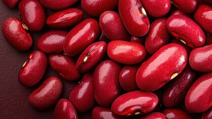 A collection of shiny red kidney beans against a dark backdrop, emphasizing their rich color and smooth texture, ideal for highlighting healthy food choices and culinary uses.