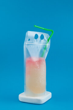 Frozen Slush Drink in plastic bag. Grapefruit Lemon Granizado. Refreshing drink in reusable pouch with drinking straw. Spill-Proof Beverages to Go