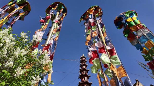 Xining, China: Panoramic footage of tall tibetan buddhist prayer flags on a windy day in the Nanchan Buddhist temple in Xining, Qinghai largest city in China.