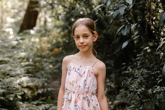 Young girl standing in the middle of the forest.