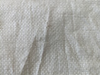 Woven White Plastic Sack Surface Texture. Detailed close-up of a white woven plastic sack with...